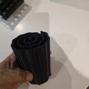Black PETG reusable fruit fly media insert with closely spaced vertical ribs arranged in a continuous spiral, photographed at Frogfather HQ